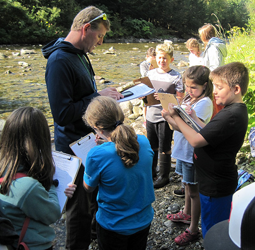Watershed alliance teacher with students next to stream